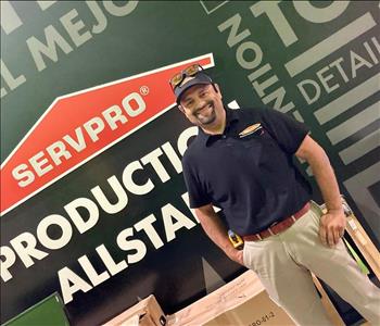 Hispanic male in front of black SERVPRO wall