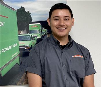 male with dark hair and servpro green trucks in background