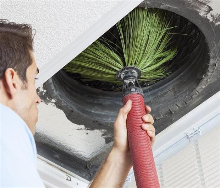 male cleaning duct with big broom